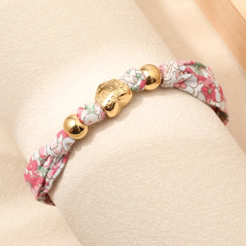Pulsera Tela con Dijes Corazón y Cuentas Doradas