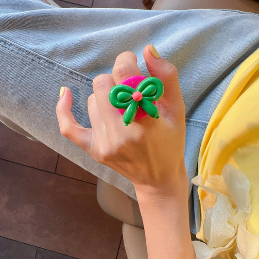 Anillo Resina Rosado con Nudo Mariposa Verde - Talla 7